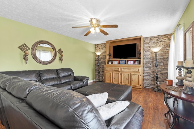 living room featuring a healthy amount of sunlight, ceiling fan, dark wood-style flooring, and a textured ceiling