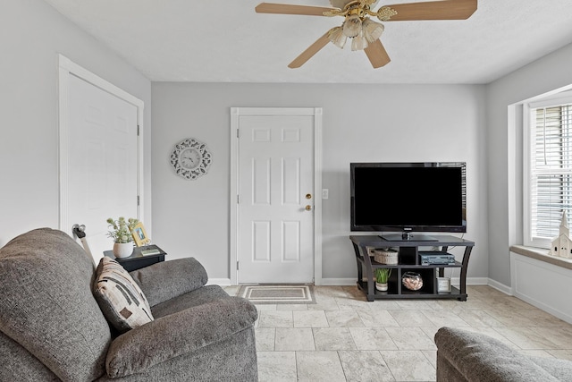 living room featuring ceiling fan and baseboards