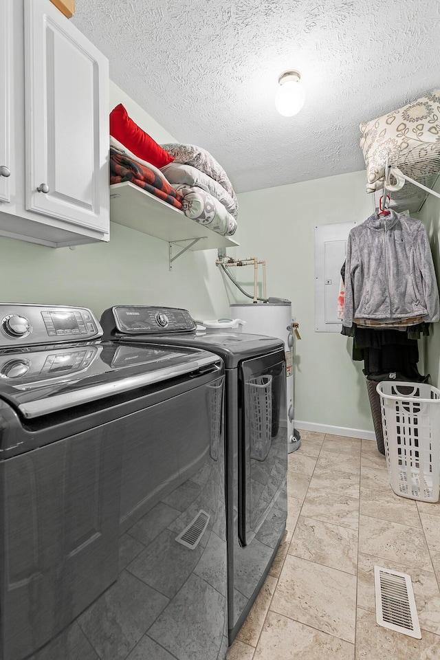 laundry area with washing machine and dryer, visible vents, baseboards, water heater, and cabinet space