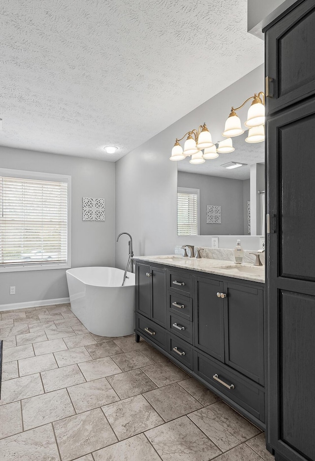 full bath featuring a soaking tub, a sink, a textured ceiling, and double vanity