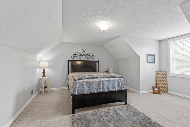 carpeted bedroom featuring visible vents, vaulted ceiling, a textured ceiling, and baseboards