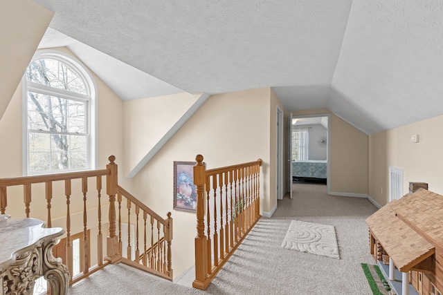 additional living space featuring visible vents, baseboards, vaulted ceiling, a textured ceiling, and carpet floors