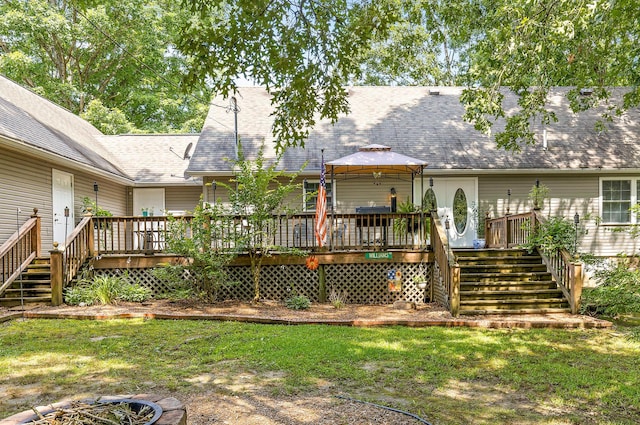 back of property with a shingled roof, a gazebo, stairway, a lawn, and a wooden deck