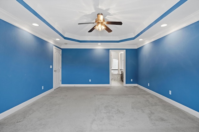 carpeted spare room with baseboards, a raised ceiling, ceiling fan, crown molding, and recessed lighting