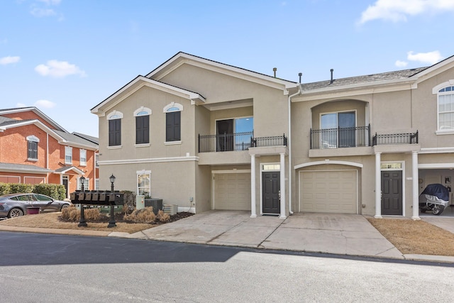 view of property with cooling unit, stucco siding, an attached garage, and driveway