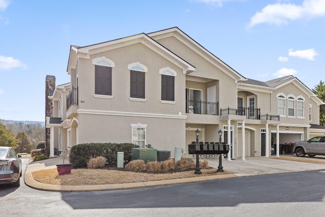 view of front of house featuring cooling unit, stucco siding, driveway, and an attached garage