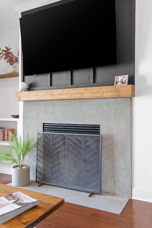 room details featuring a fireplace with flush hearth and wood finished floors