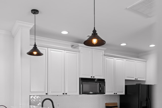 details with black appliances, decorative light fixtures, visible vents, and ornamental molding