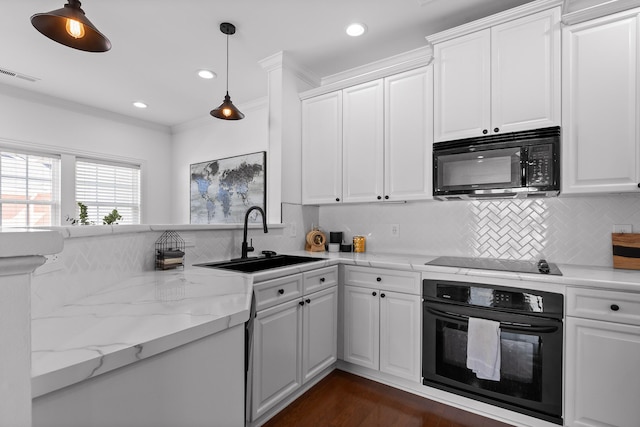 kitchen featuring black appliances, crown molding, visible vents, and a sink