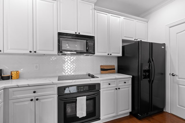 kitchen with dark wood-style floors, black appliances, white cabinetry, crown molding, and backsplash