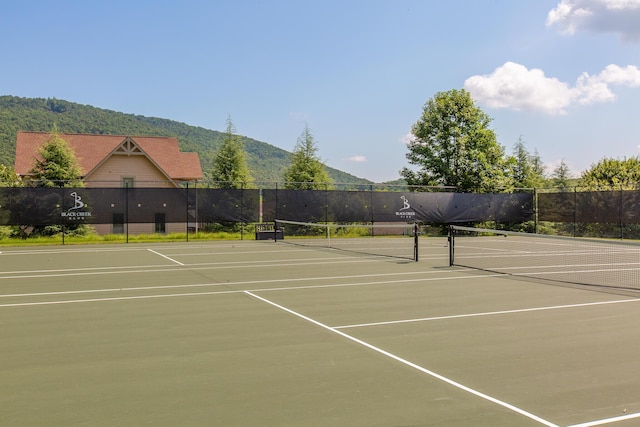 view of sport court with community basketball court, fence, and a mountain view