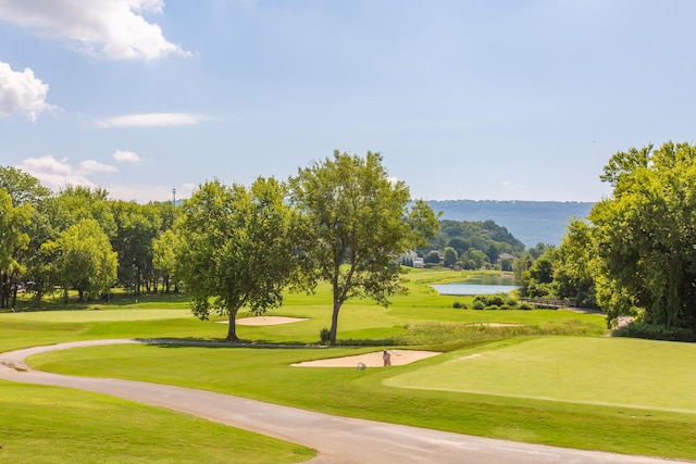 surrounding community with a yard, a water view, and view of golf course