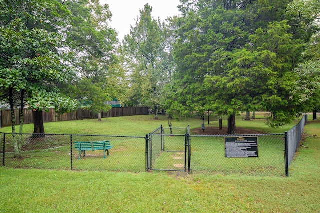 view of community with a lawn, fence, and a gate