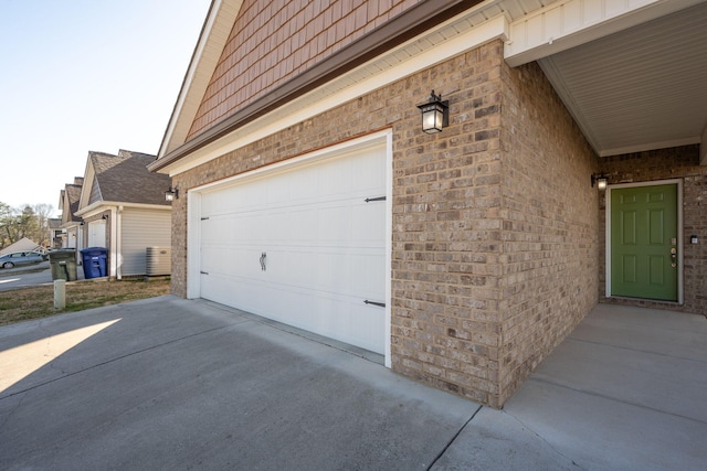 view of side of property featuring concrete driveway, brick siding, and a garage