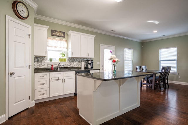 kitchen with white cabinetry, a center island, crown molding, and dark wood-style flooring