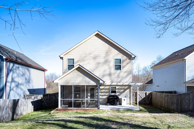 rear view of house featuring a patio area, a lawn, a fenced backyard, and a sunroom