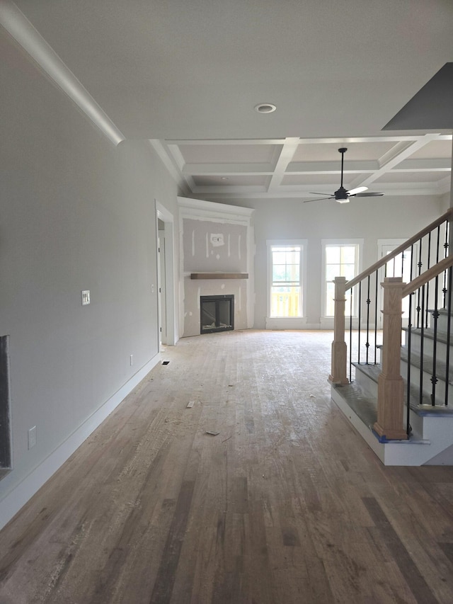 10634 Flicker Way Unit 119, Apison, TN 37302 - unfurnished living room featuring coffered ceiling, wood finished floors, ceiling fan, stairs, and a glass covered fireplace