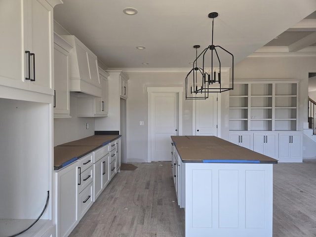 10634 Flicker Way Unit 119, Apison, TN 37302 - kitchen with dark countertops, light wood-type flooring, a center island, custom range hood, and a chandelier