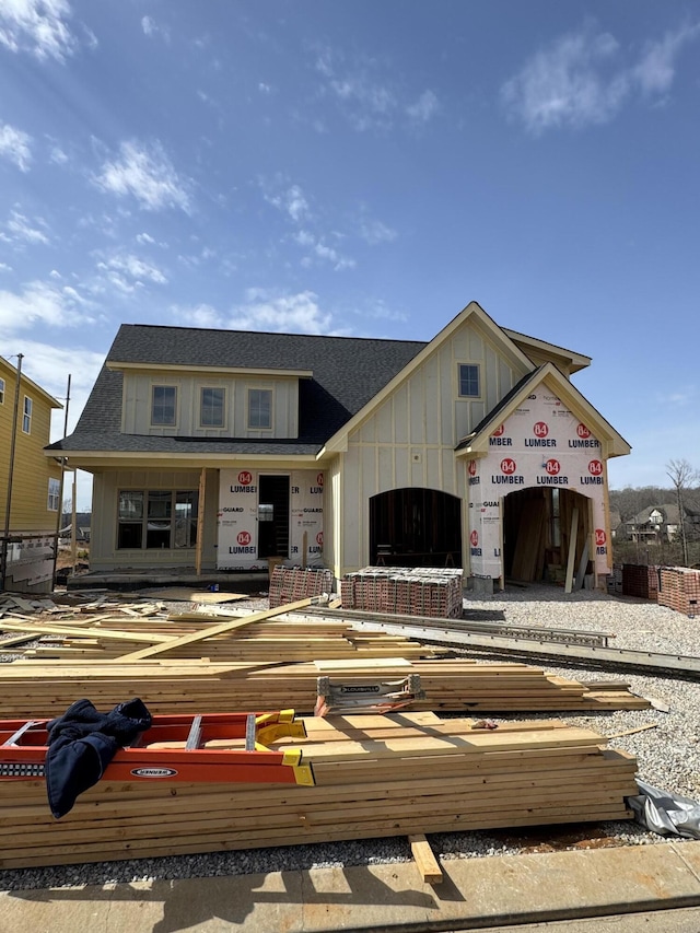 view of front facade with a garage, board and batten siding, and roof with shingles