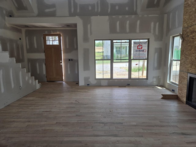 unfurnished living room with a large fireplace and wood finished floors
