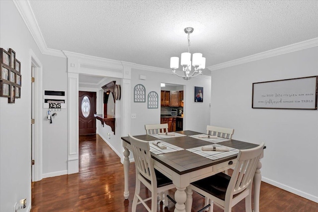 dining area with a chandelier, a textured ceiling, wood finished floors, baseboards, and ornamental molding