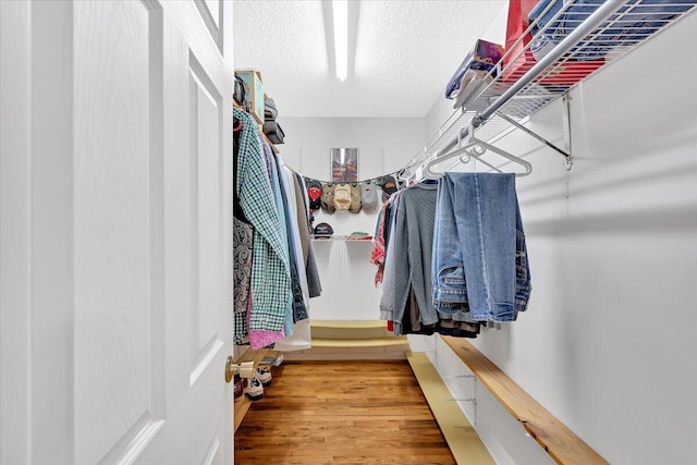 walk in closet with wood finished floors