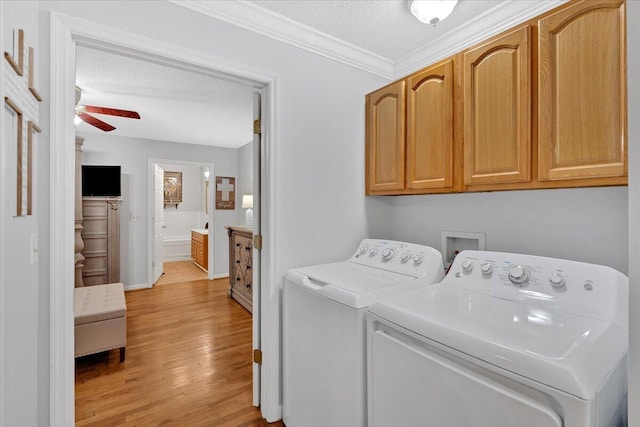 clothes washing area featuring a textured ceiling, a ceiling fan, light wood-style floors, cabinet space, and washing machine and clothes dryer