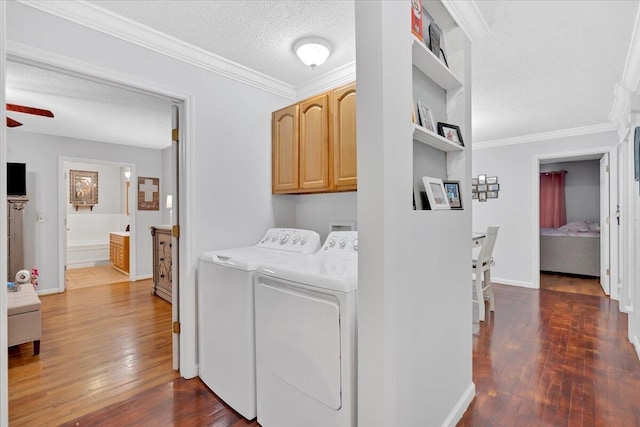 washroom with a textured ceiling, dark wood-style flooring, cabinet space, and washer and dryer