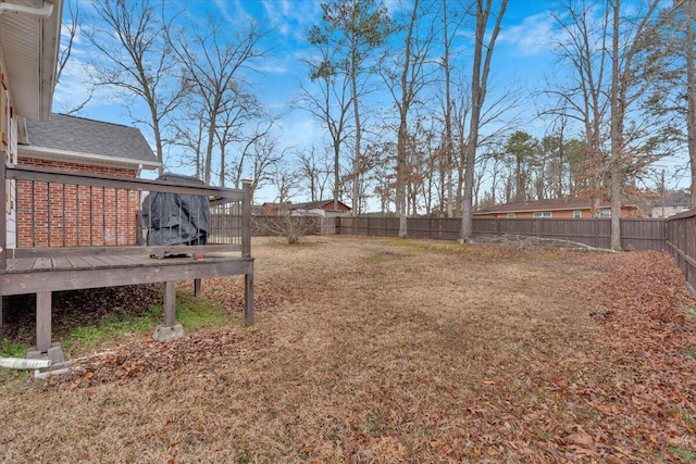 view of yard with a fenced backyard and a wooden deck