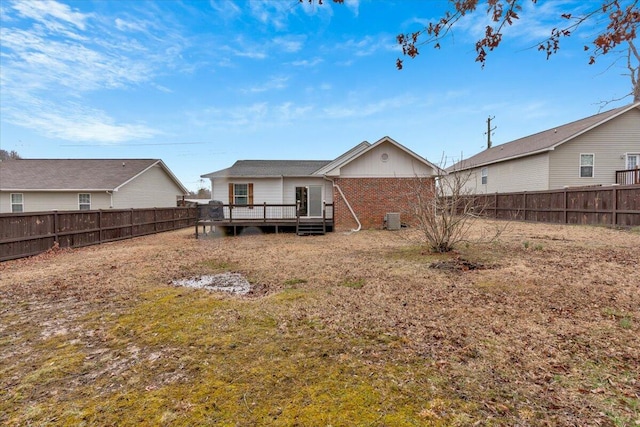 rear view of house featuring central AC, brick siding, a fenced backyard, and a wooden deck