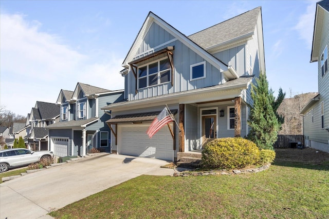 view of front of home featuring driveway, a garage, a residential view, board and batten siding, and a front yard