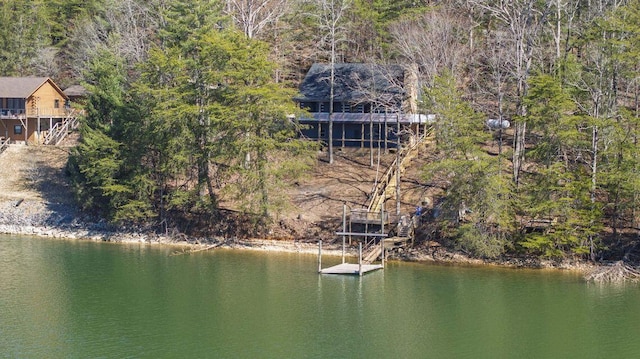 water view featuring a floating dock and a forest view