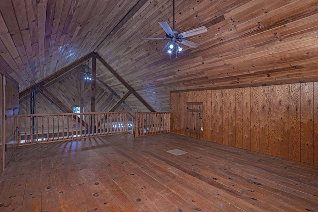 additional living space with hardwood / wood-style floors, wooden ceiling, a ceiling fan, and wooden walls