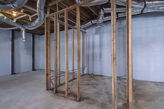 unfinished basement featuring concrete block wall