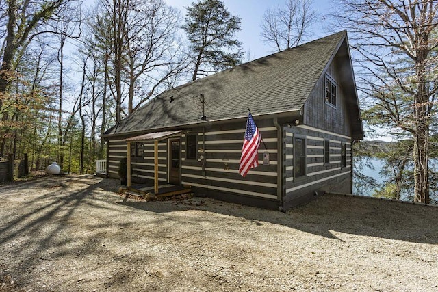 view of property exterior with roof with shingles