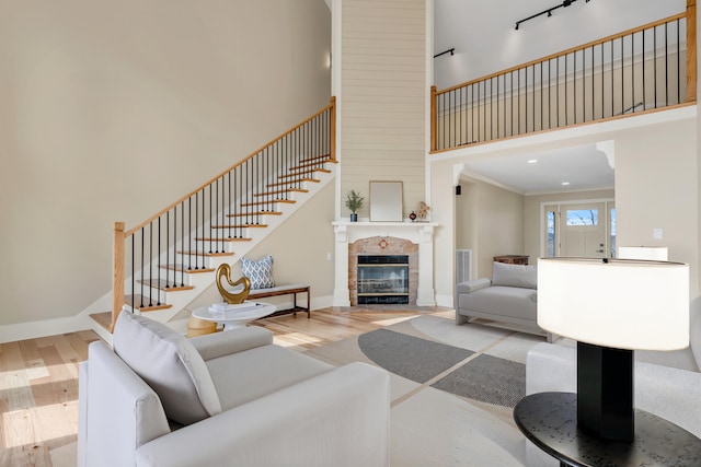 living area featuring a high ceiling, baseboards, and wood finished floors