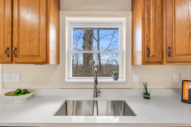 kitchen with brown cabinets, light countertops, and a sink