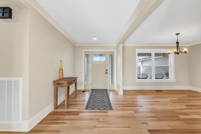 entryway featuring light wood-style floors, baseboards, visible vents, and an inviting chandelier