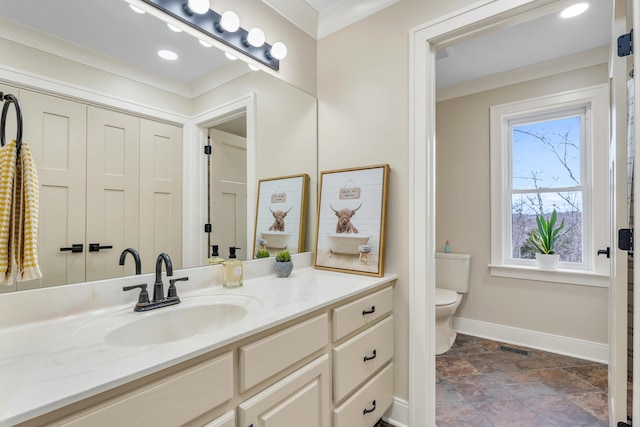 bathroom with toilet, vanity, visible vents, baseboards, and crown molding