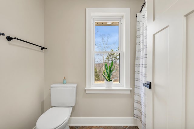 bathroom with baseboards and toilet