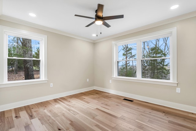 empty room with visible vents, baseboards, and wood finished floors