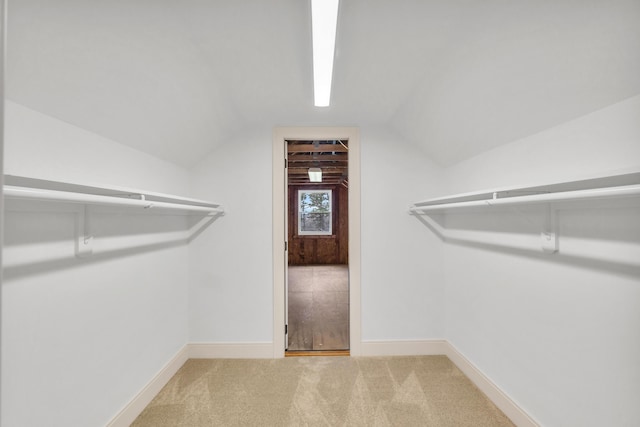 spacious closet featuring lofted ceiling and carpet flooring