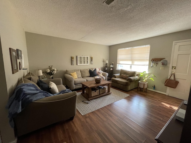 living area with a textured ceiling, dark wood finished floors, and baseboards