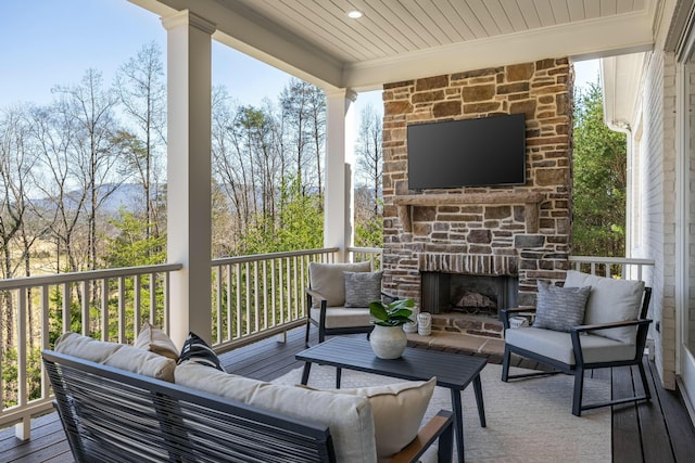 wooden terrace featuring an outdoor living space with a fireplace