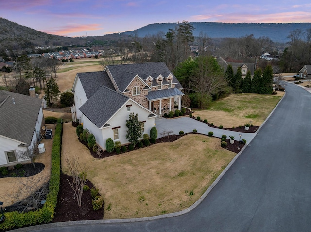 aerial view at dusk featuring a mountain view