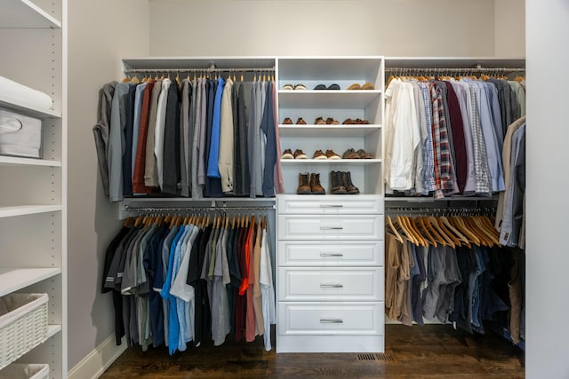 walk in closet with dark wood-style flooring