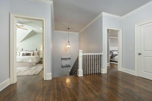 hall featuring an upstairs landing, crown molding, and wood finished floors