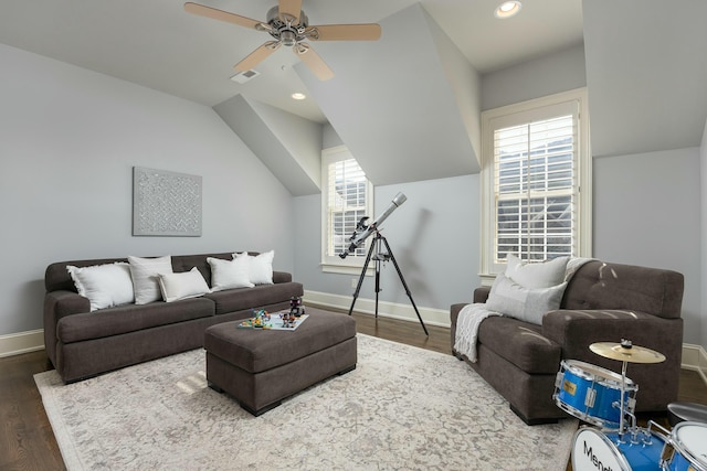 living area with visible vents, baseboards, ceiling fan, vaulted ceiling, and wood finished floors