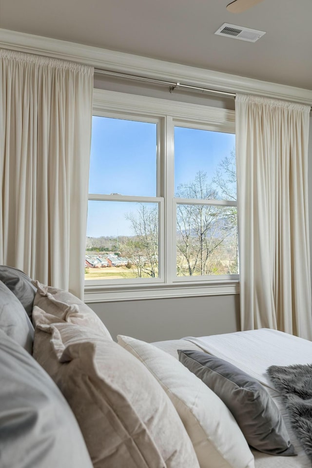 bedroom with visible vents and multiple windows