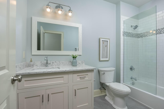 bathroom with vanity, baseboards, tub / shower combination, tile patterned flooring, and toilet